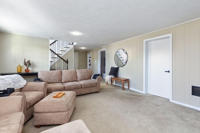 carpeted living room featuring stairs and baseboards