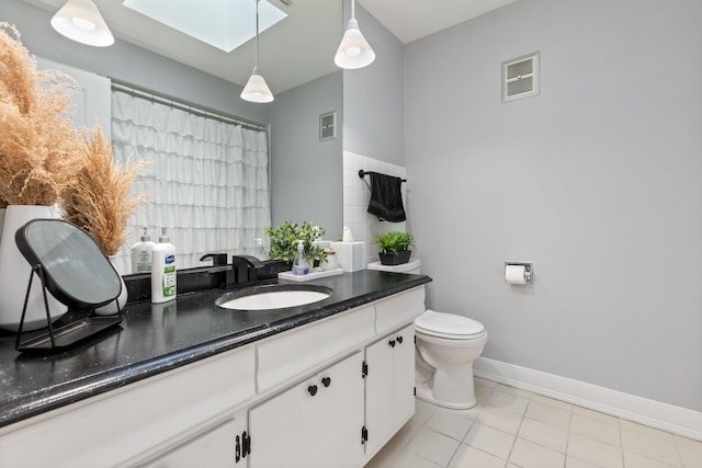 bathroom with visible vents, toilet, a skylight, and vanity