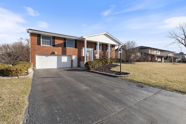 greek revival inspired property featuring a front yard, a garage, brick siding, and driveway