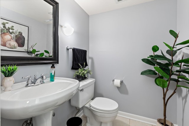 bathroom featuring tile patterned flooring, visible vents, baseboards, toilet, and a sink