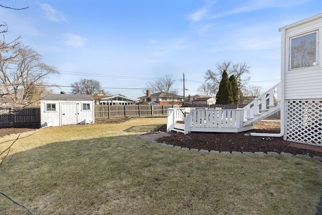 view of yard featuring a wooden deck, an outbuilding, a fenced backyard, and a shed