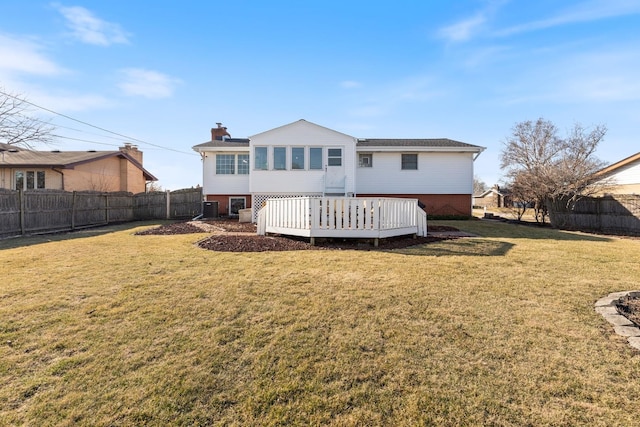 rear view of property featuring a fenced backyard, a lawn, and a wooden deck