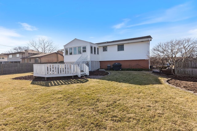 back of house with a deck, fence, and a lawn