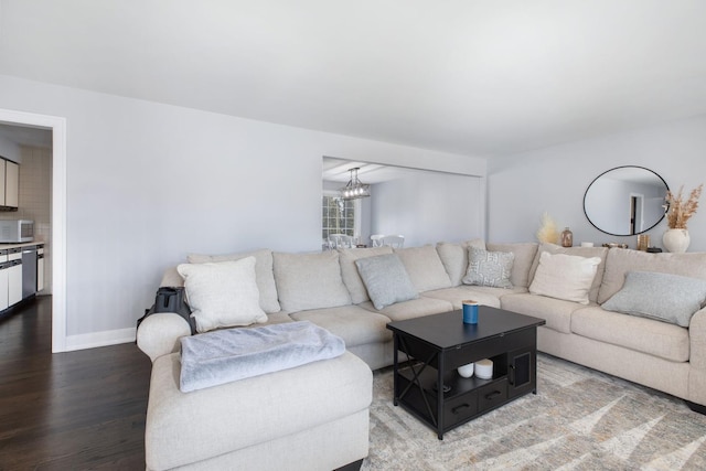 living room featuring baseboards, an inviting chandelier, and wood finished floors