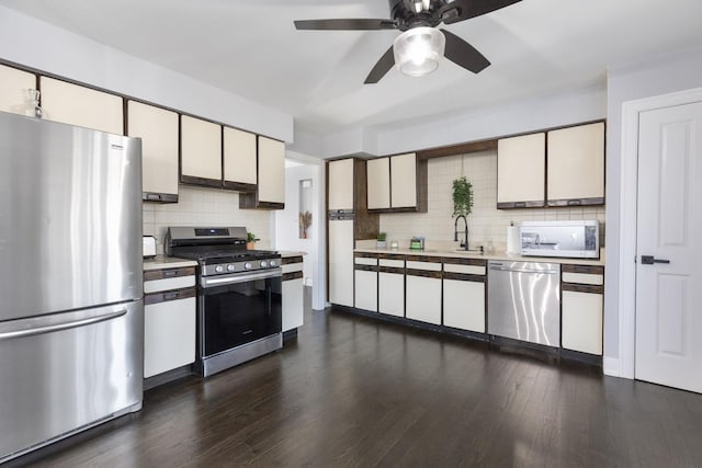 kitchen featuring a ceiling fan, tasteful backsplash, appliances with stainless steel finishes, light countertops, and dark wood-style flooring