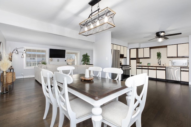 dining room with dark wood-style floors, baseboards, and ceiling fan