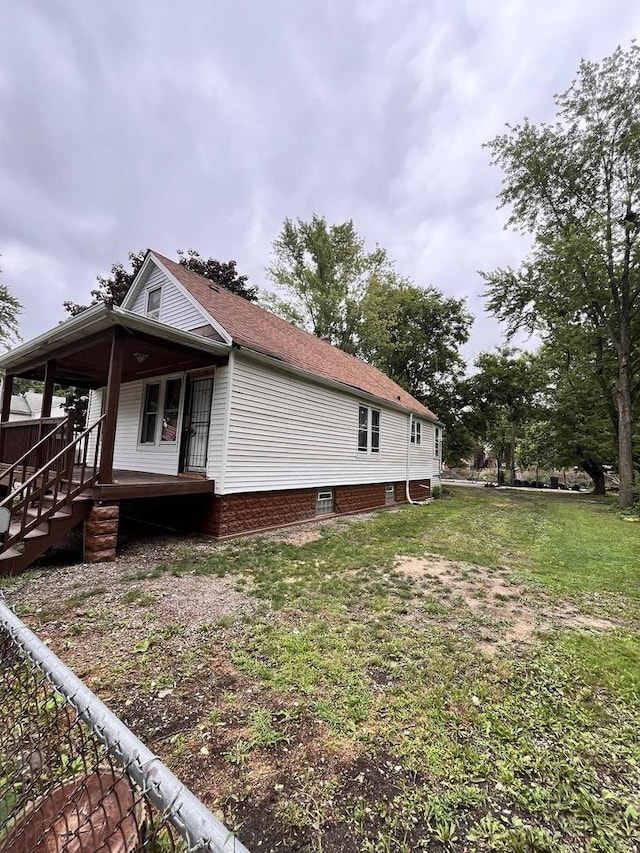 view of home's exterior featuring a porch and a yard