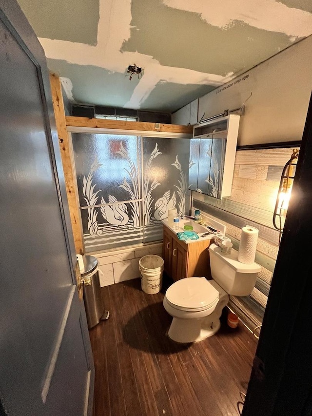 bathroom featuring an enclosed shower, toilet, and wood finished floors