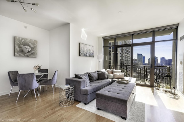 living area with a wall of windows, baseboards, a city view, and wood finished floors