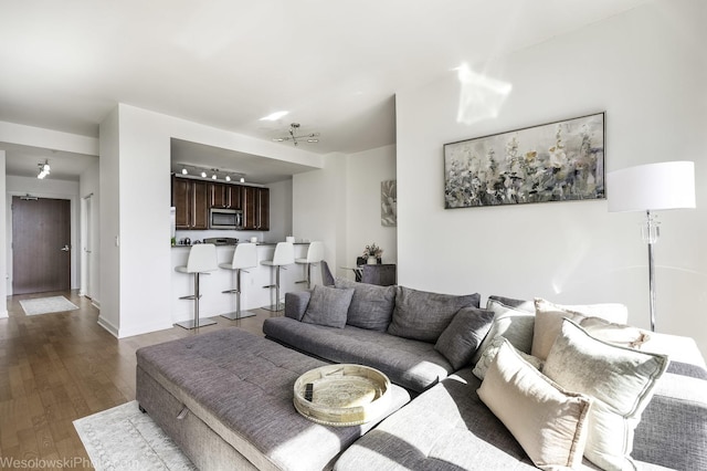 living area featuring baseboards and dark wood finished floors