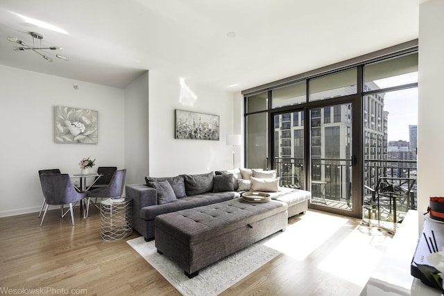 living room featuring a wall of windows, baseboards, a city view, and wood finished floors