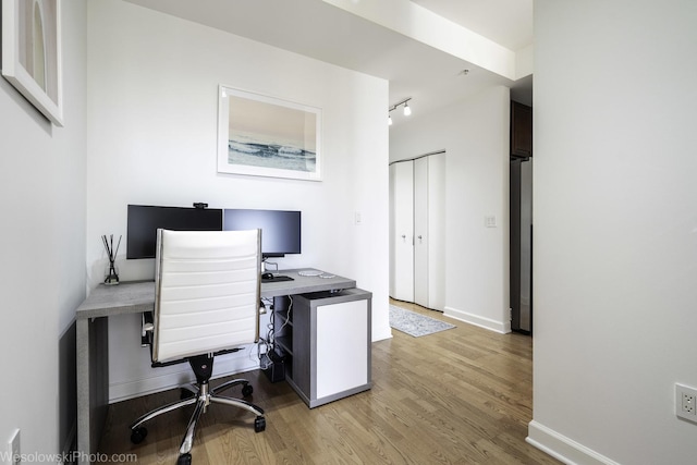 home office with light wood finished floors and baseboards