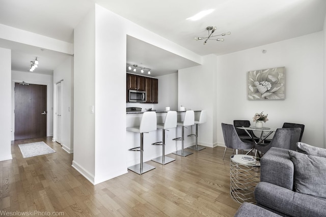 interior space with rail lighting, baseboards, and light wood-style floors