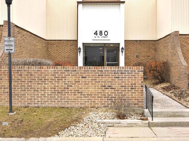 doorway to property with brick siding