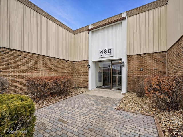 view of exterior entry with brick siding