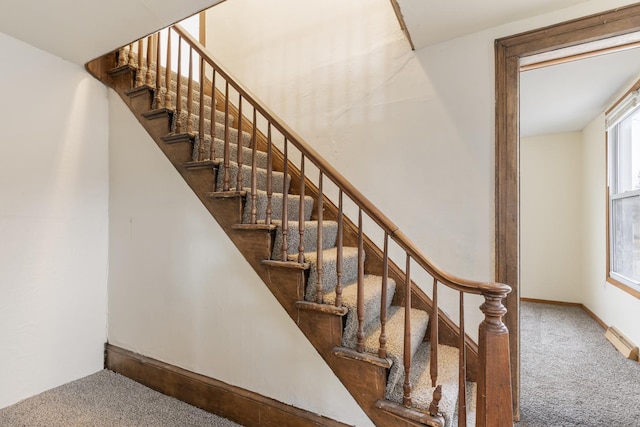 stairway with baseboards and carpet floors