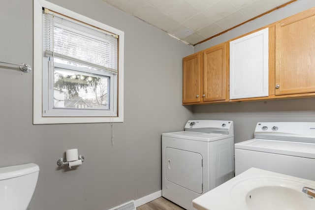 washroom featuring washer and dryer, baseboards, and a sink