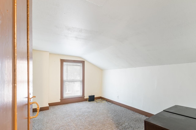 bonus room featuring vaulted ceiling, carpet flooring, and baseboards