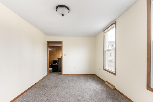 unfurnished room with carpet flooring, baseboards, and a baseboard radiator