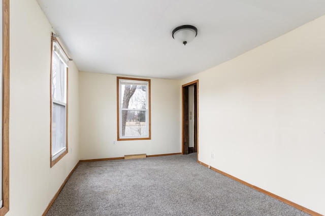 unfurnished room with visible vents, baseboards, and carpet