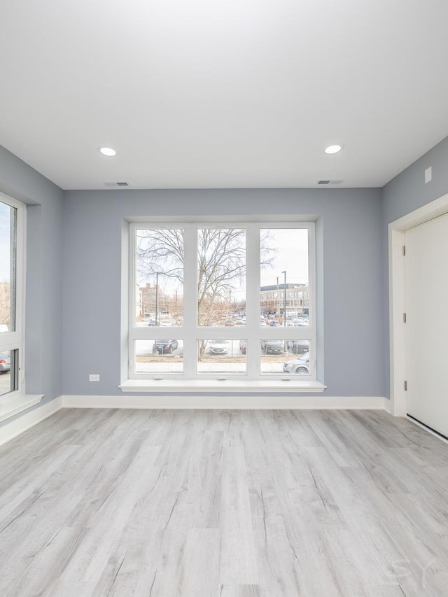 spare room with recessed lighting, baseboards, and light wood finished floors