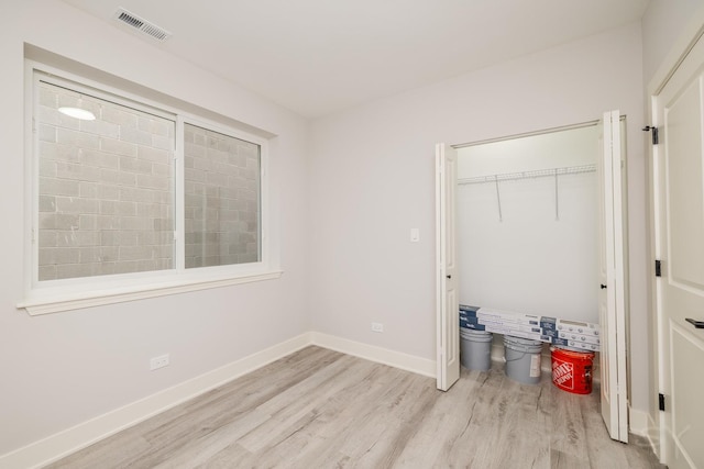 bedroom with visible vents, baseboards, a closet, and light wood finished floors