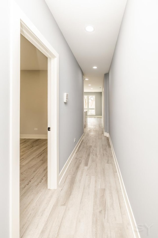 hallway with recessed lighting, baseboards, and light wood finished floors