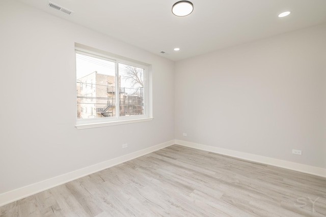 unfurnished room featuring recessed lighting, visible vents, light wood-style flooring, and baseboards