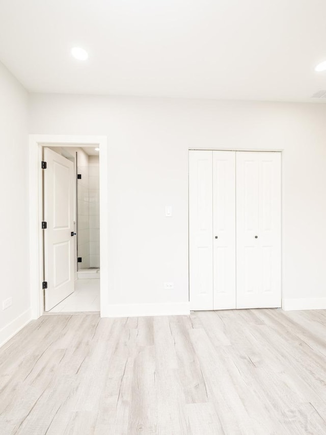 unfurnished bedroom featuring recessed lighting, light wood-style floors, baseboards, and a closet