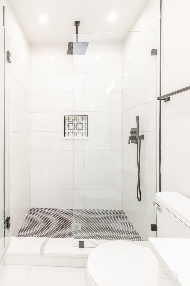 full bath featuring a shower stall and toilet