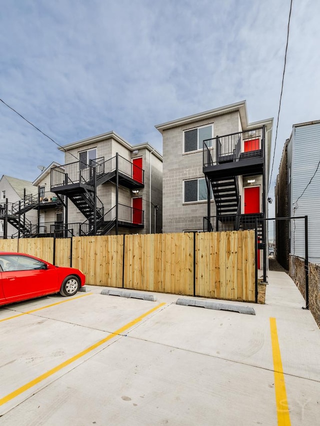 view of basketball court featuring a fenced front yard, stairs, and a gate