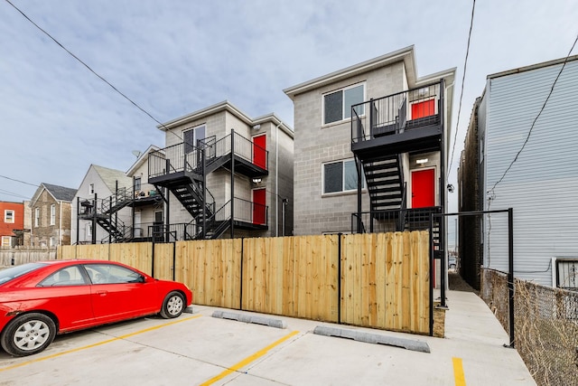 exterior space featuring stairs, a gate, uncovered parking, and a fenced front yard