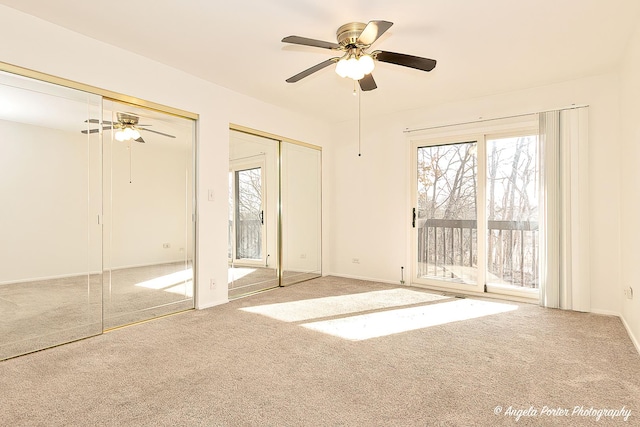 unfurnished bedroom with carpet flooring, multiple windows, two closets, and access to outside