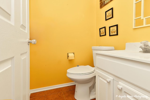 half bath with vanity, tile patterned floors, toilet, and baseboards