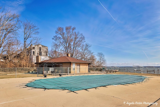 community pool with a patio and fence