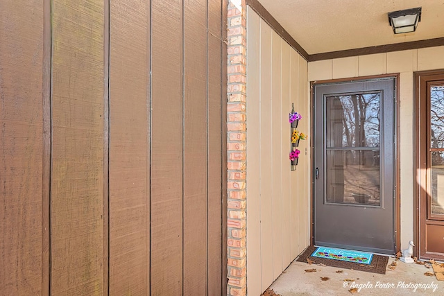 doorway to property featuring brick siding and board and batten siding