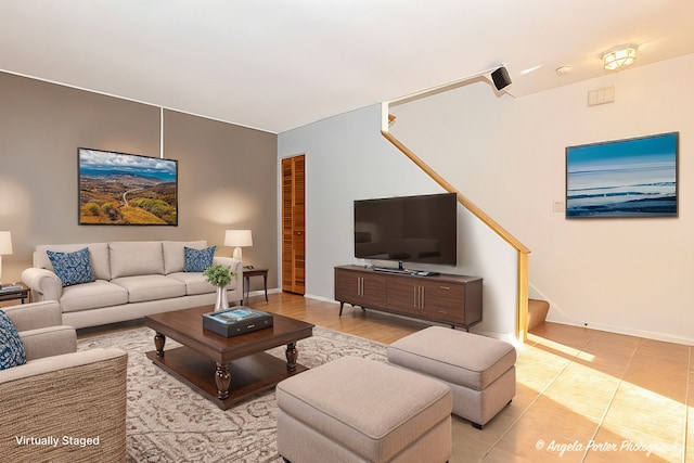 living room featuring tile patterned floors, stairway, and baseboards