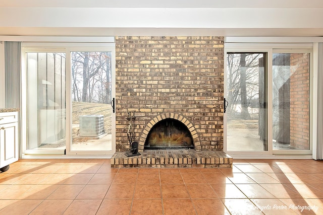 unfurnished living room with tile patterned flooring and a brick fireplace