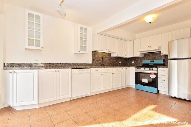 kitchen with under cabinet range hood, appliances with stainless steel finishes, tasteful backsplash, and a sink