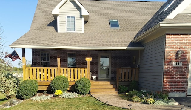 exterior space with covered porch, brick siding, and a shingled roof