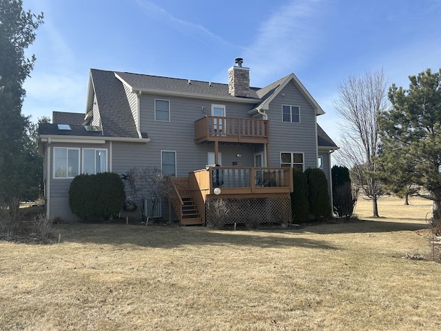 back of house with a wooden deck, a lawn, a chimney, and a shingled roof