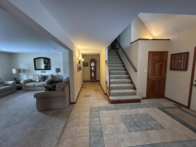 entrance foyer with light tile patterned flooring, stairway, and baseboards