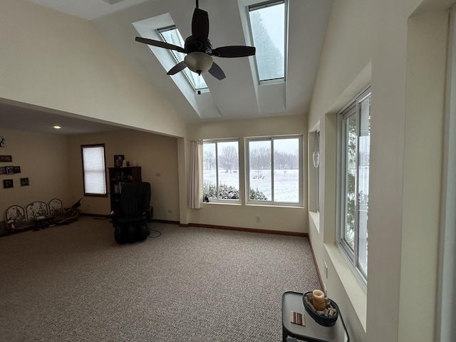 interior space with ceiling fan, a healthy amount of sunlight, a skylight, and carpet flooring