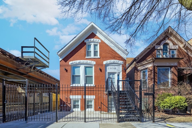 view of front of house featuring a fenced front yard, brick siding, and a gate