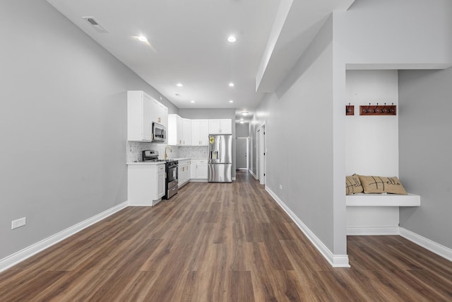 kitchen with baseboards, dark wood finished floors, light countertops, appliances with stainless steel finishes, and backsplash