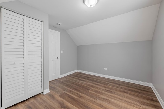 additional living space with lofted ceiling, baseboards, and wood finished floors