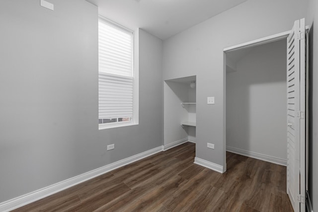 unfurnished bedroom with dark wood-style floors and baseboards