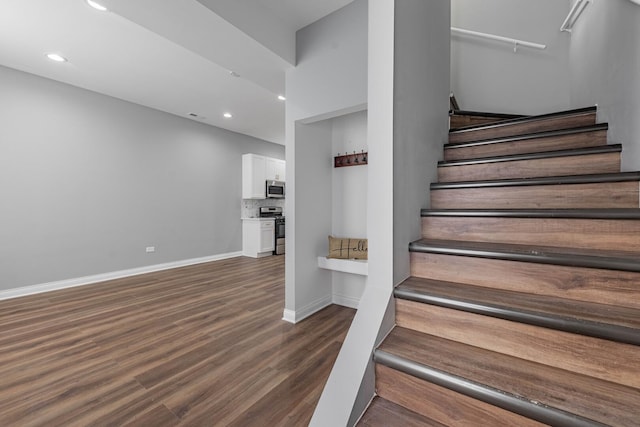 stairway with recessed lighting, visible vents, baseboards, and wood finished floors