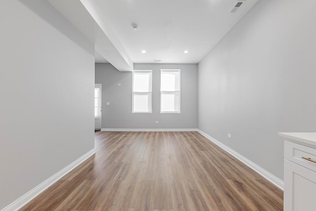 empty room with recessed lighting, visible vents, baseboards, and light wood finished floors