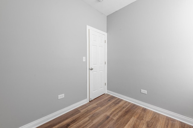 spare room featuring baseboards and wood finished floors